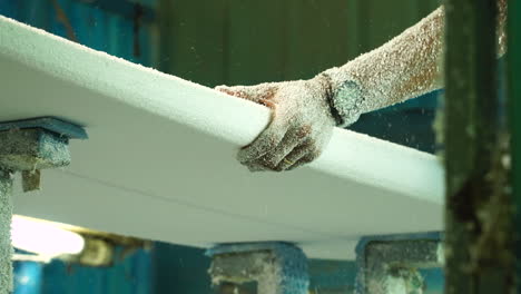 Slow-motion-man's-hands-smoothing-DIY-surf-foam-board-in-workshop-with-sander