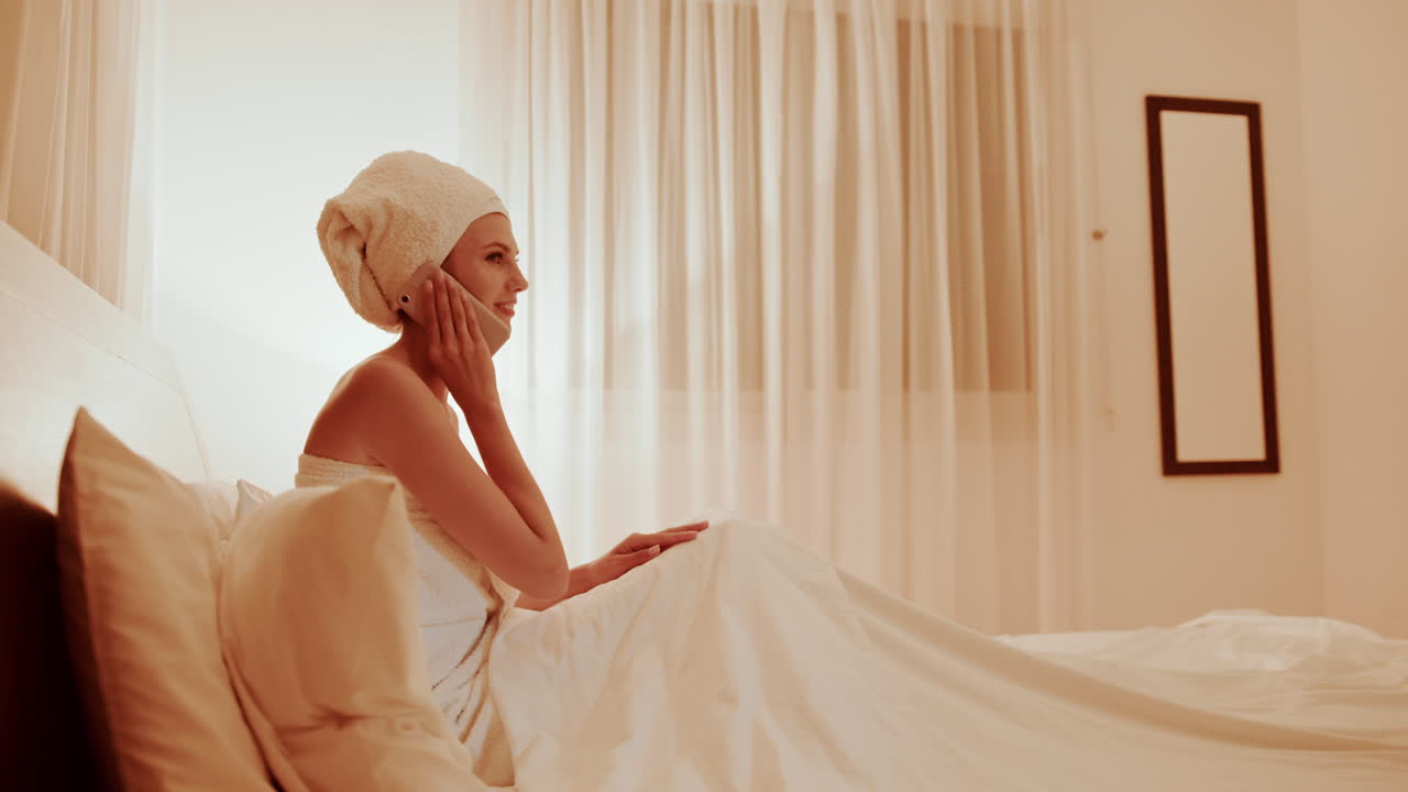 침대에서 전화로 얘기하는 여자