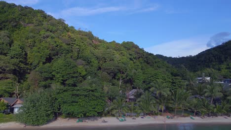 Dramatic-aerial-top-view-flight-Huts-Resort-Beach-Bungalows,-Jungle-hilly-Island-Thailand-2022