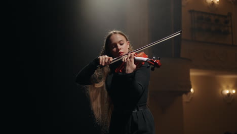 female violin player is practicing to play violin in music school portrait of female violinist in music hall