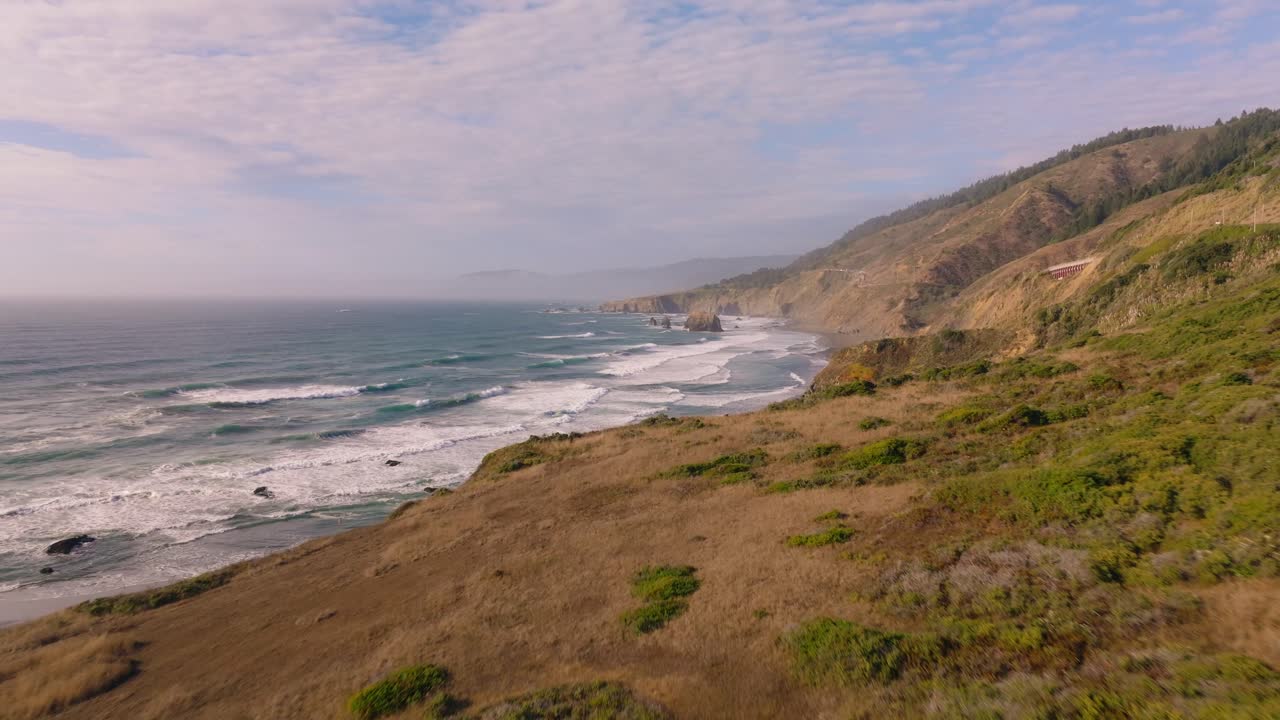 Aerial view of California coast, waves and cliffs in serene morning light