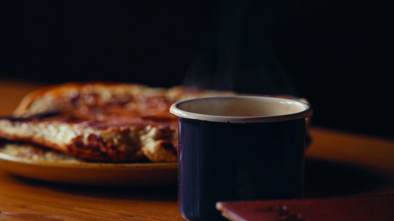 Steaming Mug Of Hot Coffee On Wooden Table Next To Plate Of Pancakes. closeup shot
