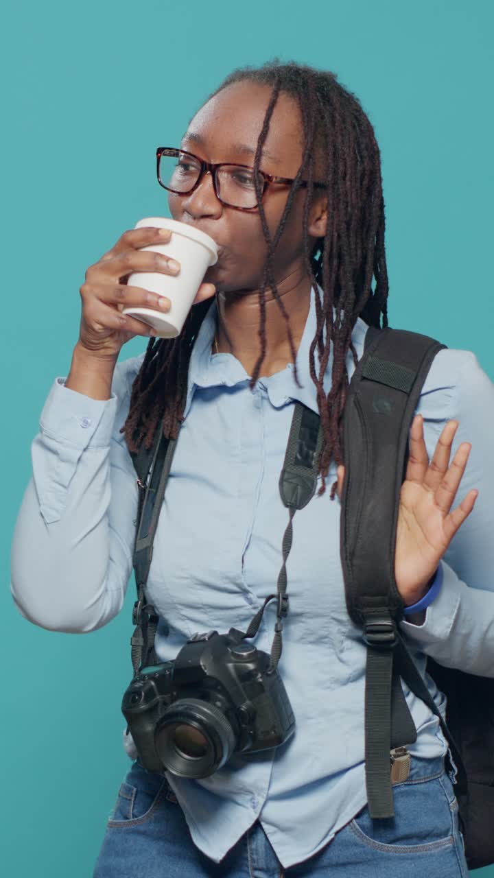 Donna con caffè, fotocamera e zaino