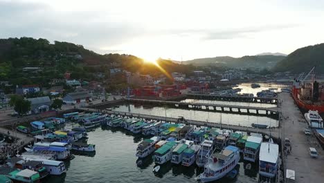 vista aérea con vistas a los barcos, en el pueblo pesquero de labuan bajo, puesta de sol, en flores, indonesia - pan, tiro de drones