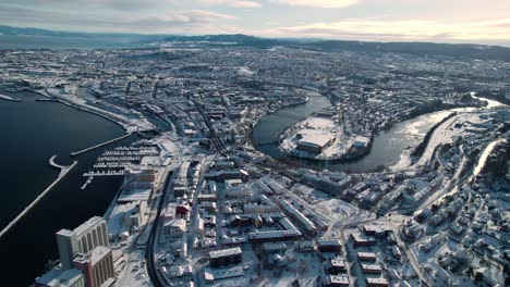 drone shot of trondheim, norway on sunny winter day, buildings, harbor and river