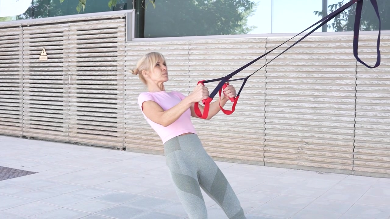 A woman exercises outdoors with resistance bands for various fitness activities