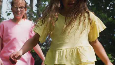 group of children having fun with friends bouncing on trampoline in garden