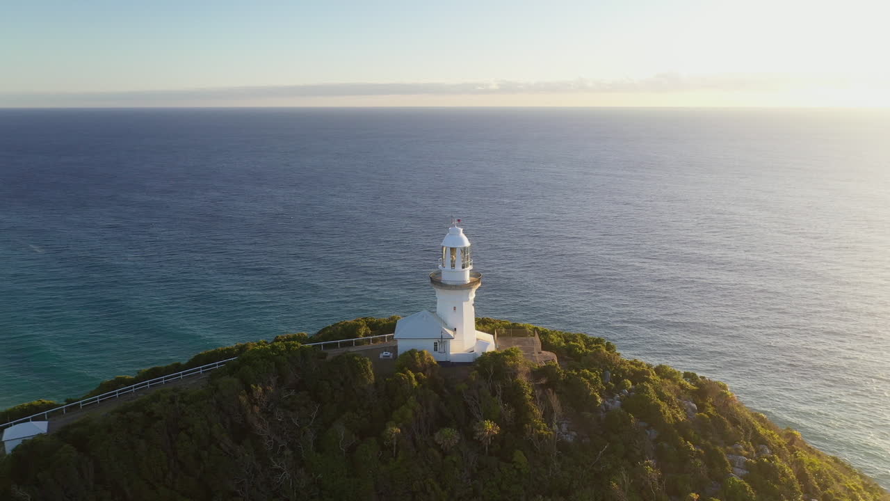 toma cinematográfica de drones girando alrededor del faro del cabo humeante en australia con isla verde y la cornisa en el fondo