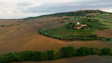Aerial-at-sunset-over-a-typical-Tuscany-landscape-near-Pienza,-Province-of-Siena,-Italy