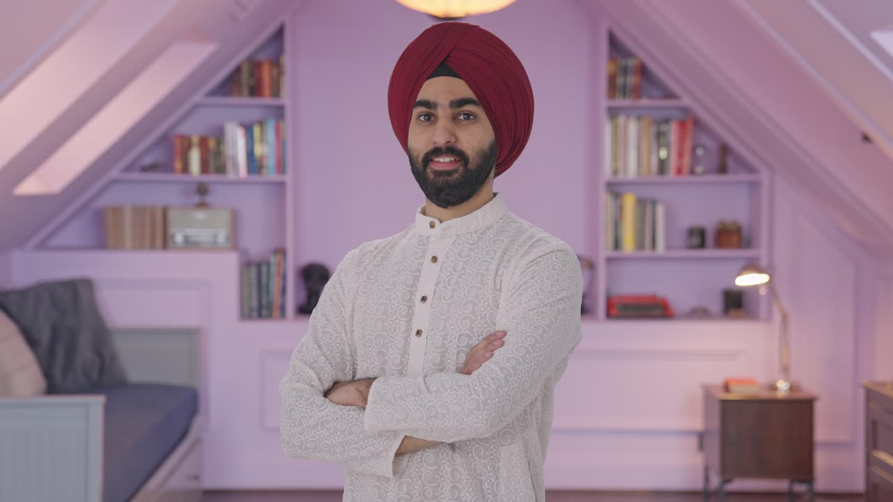 Ritratto di uomo indiano Sikh felice in piedi con le braccia conserte