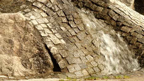 El-Agua-Fluye-Ondulando-A-Través-De-Un-Canal-Pavimentado-En-Un-Parque-Infantil-En-Un-Día-Soleado