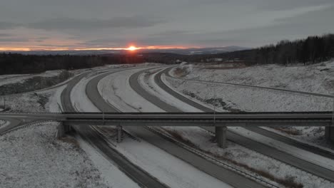 Vista-Panorámica-De-Las-Carreteras-En-El-Paisaje-Invernal-Con-Los-Coches-Que-Viajan-Durante-El-Amanecer