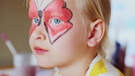 the girl applied a festive make-up in the form of butterflies