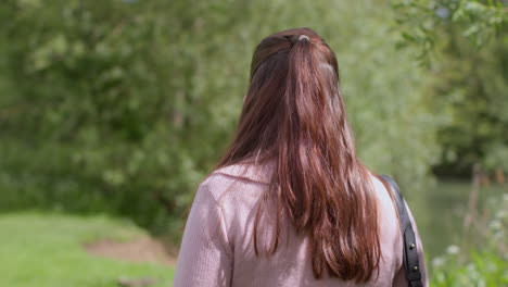 Stressed-And-Worried-Woman-Outdoors-With-Financial-Worries-About-Cost-Of-Living-Crisis-Debt-And-Paying-Bills-Looking-At-Mobile-Phone-By-Riverbank