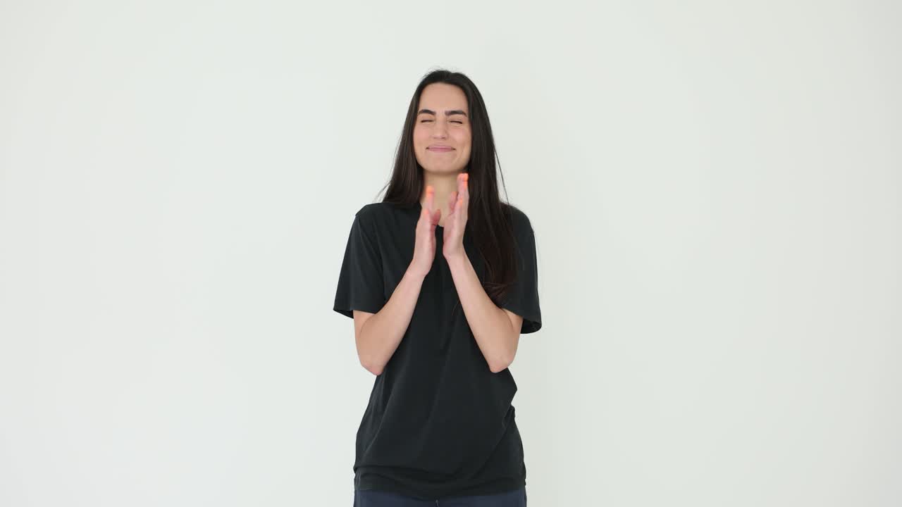 Happy Young Woman Clapping Hands and Smiling in Studio