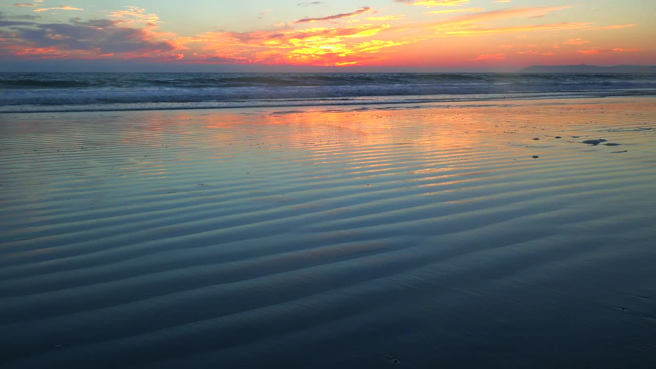 Waves roll in along a beautiful ocean coast at sunset