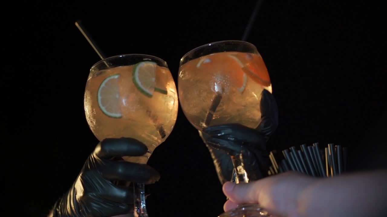 el camarero entrega dos cócteles de ginebra con rebanadas de limón en el vaso.