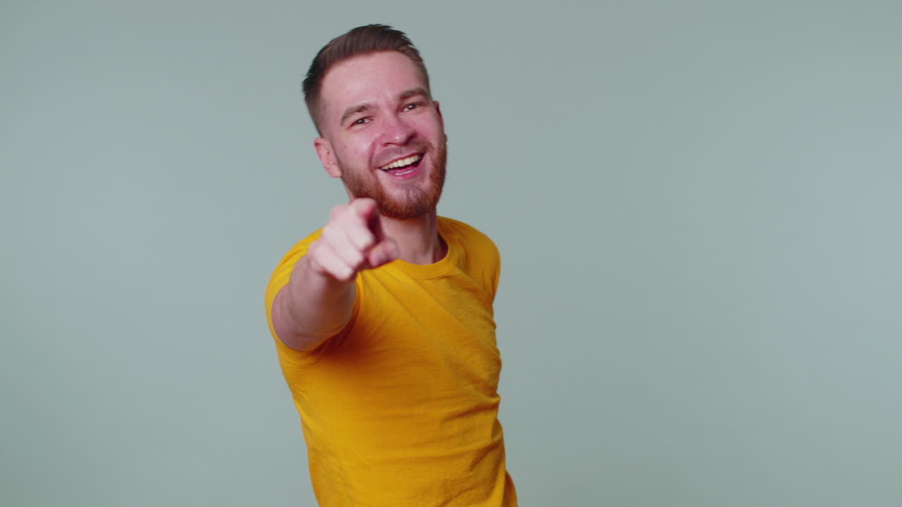 hombre señalando con el dedo a la cámara, riendo en voz alta, burlándose de la apariencia ridícula, broma divertida