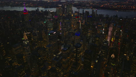 Vista-Aérea-De-Rascacielos-En-El-Centro-De-La-Ciudad-Después-Del-Atardecer.-Vista-Panorámica-De-Edificios-De-Gran-Altura-Iluminados-Al-Atardecer.-Manhattan,-Ciudad-De-Nueva-York,-Estados-Unidos