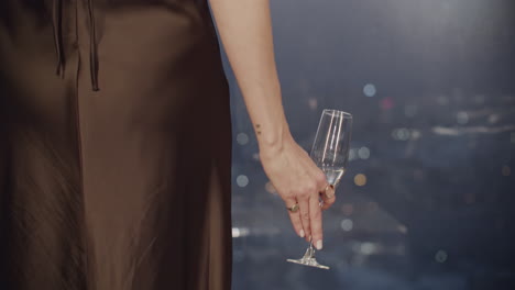 woman holding champagne glass at night party