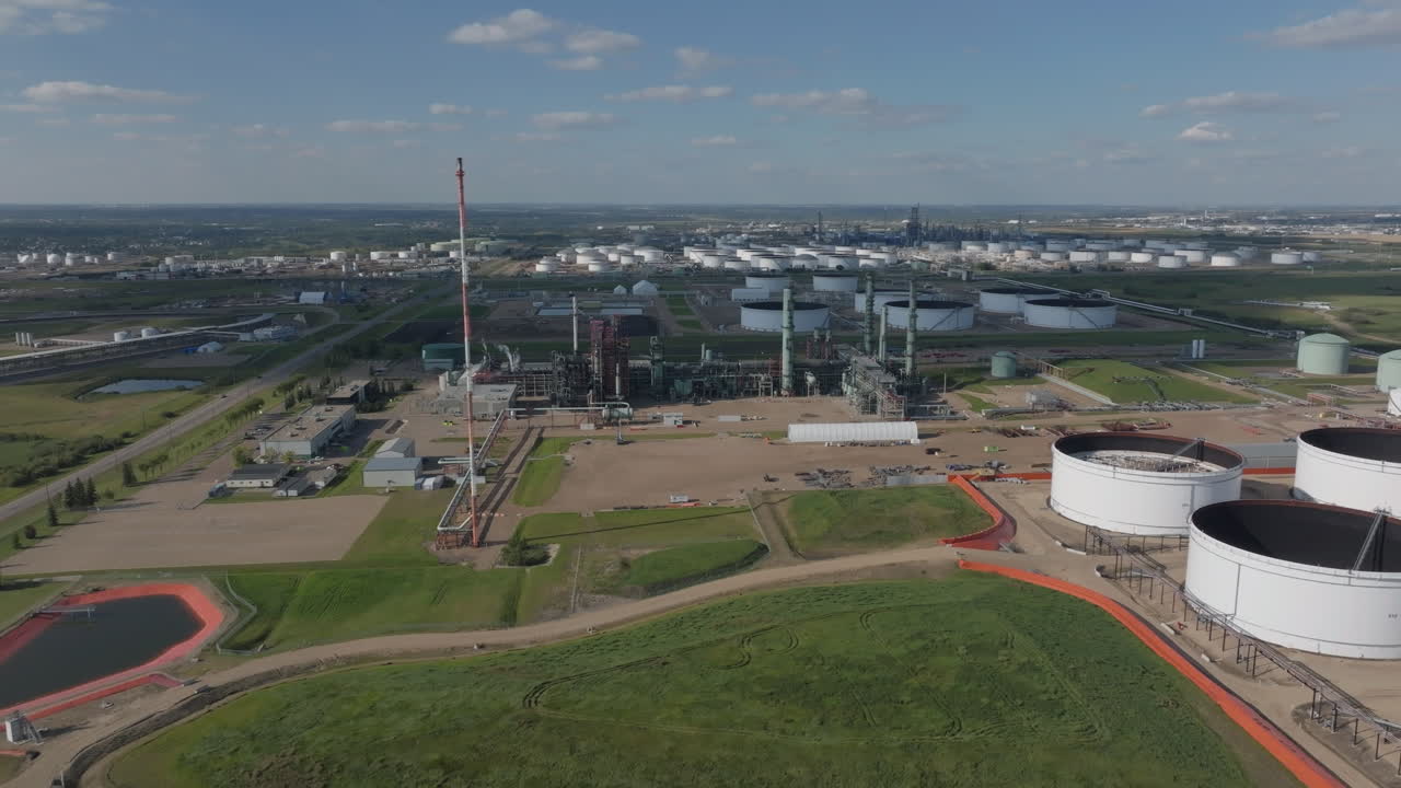 Aerial view of an oil refinery with storage tanks on a sunny day