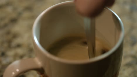 Nahaufnahme-Der-Männlichen-Hand,-Die-Heißen-Kaffee-In-Einem-Becher-Rührt