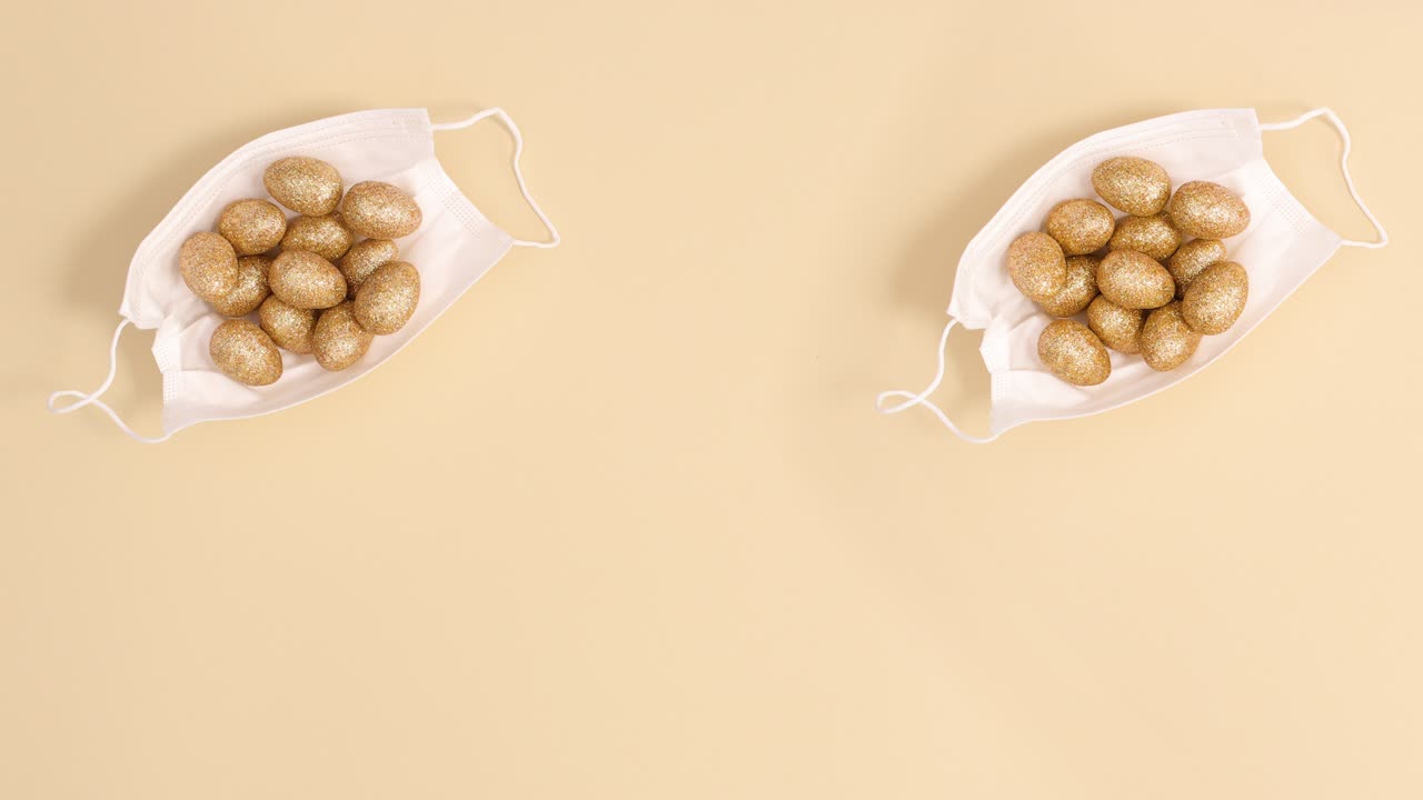 황금빛 반이는 이스터 달을 가진 두 개의 얼굴 마스크가 베이지색 배경에서 움직입니다.