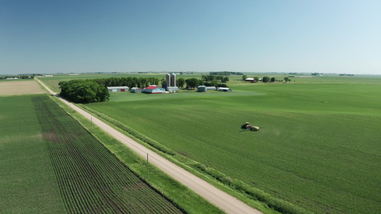 Luftpanorama, traktor sprøjter pesticid på friske afgrøder på landbrugsland