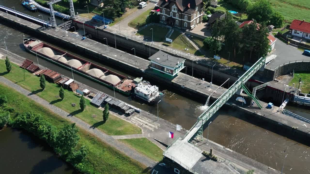 vista aérea de una barcaza de arena en la esclusa con los motores en marcha