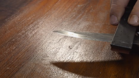 edge of kitchen knife is sharpened using a wet whetstone, remove burrs