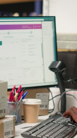 vertical video african american male employee scanning packages in a large warehouse