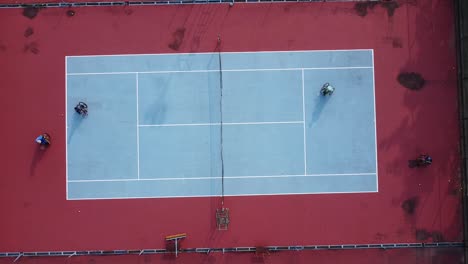 people in wheelchair playing tennis on court