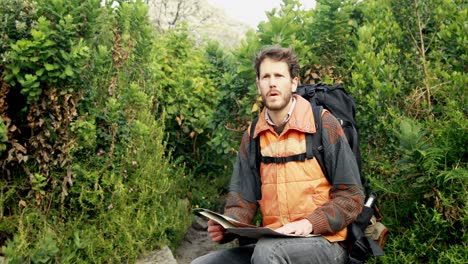 male hiker looking at map in countryside 4k