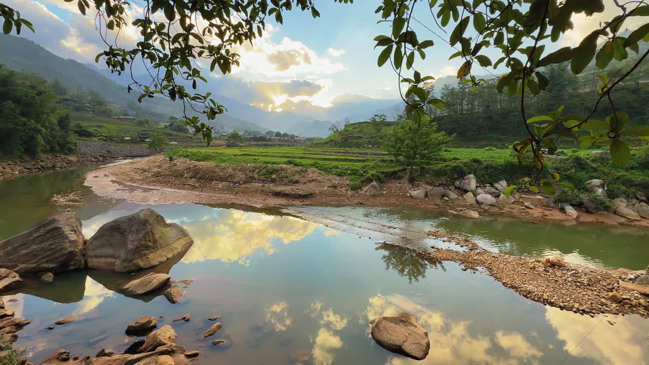 Tranquil river landscape in Sa Pa, Vietnam, with mountain reflections, golden skies, and peaceful rural nature. Serene, untouched beauty at sunset.