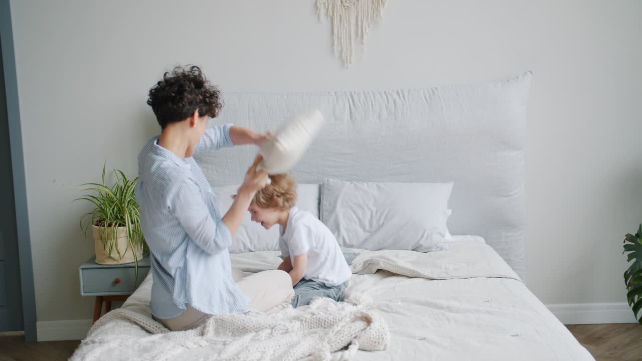 Mother and Son Having Fun with Pillow Fight