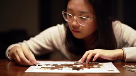 focused on the challenge: a young individual diligently assembles a complex puzzle on a table, showcasing precision and patience in each piece placed