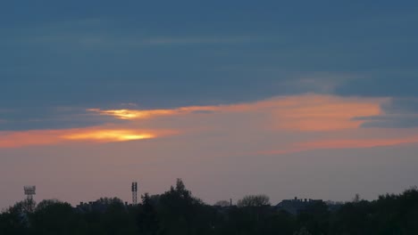 timelapse of beautiful scenic sunset over the city with sun shining through clouds, wide shot