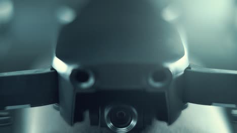 macro drone camera lens on a stabilizer, propellers and sensors, hyper close up, aerial photography gear, professional film equipment, studio lighting, upwards movement, 120 fps slow motion