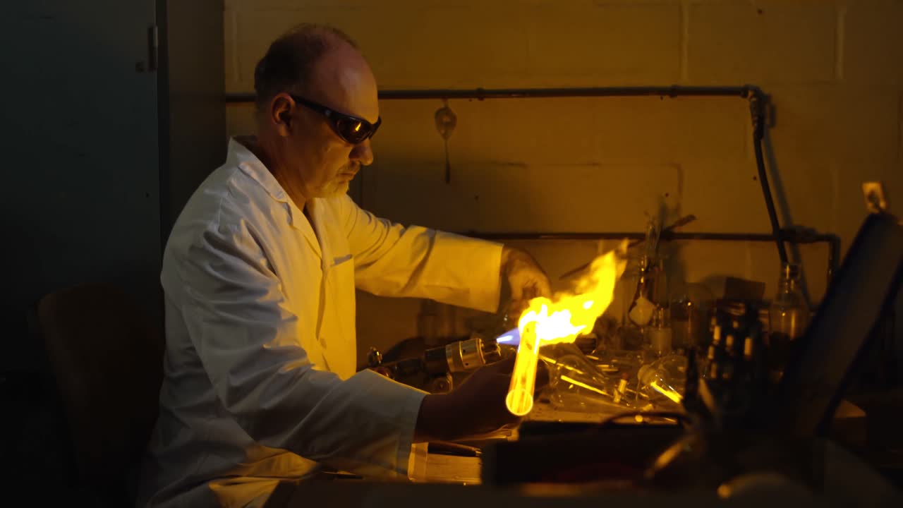 vista lateral de un trabajador masculino maduro creando vidrio en una fábrica de vidrio 4k