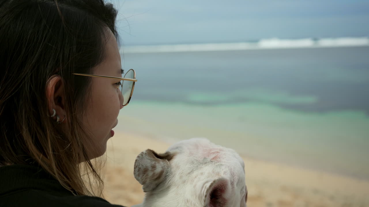 프렌치 불독을 껴안고 키스하는 여자의 클로즈업 샷