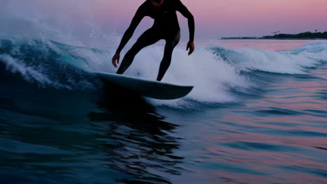un surfista montando una ola al atardecer