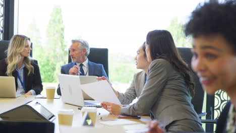 Multi-Cultural-Business-Team-Meeting-And-Collaborating-Around-Table-In-Modern-Office-Building