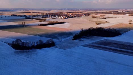 Twilight-Descends-on-Snow-Covered-Rural-Landscape-with-Distant-Village