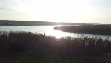 view of the forest on the background of a quiet river at sunset in the summer. aerial view