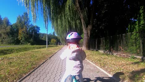 Niño-Pequeño-Montando-Una-Bicicleta-De-Equilibrio---Bicicleta-De-Empuje-Con-Casco-En-Una-Acera