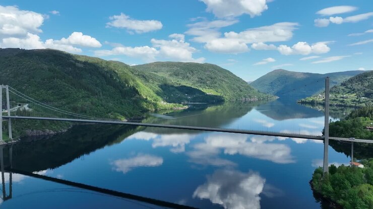 Osteroy bridge in western Norway in beautiful weather with sky reflection in sea, aerial