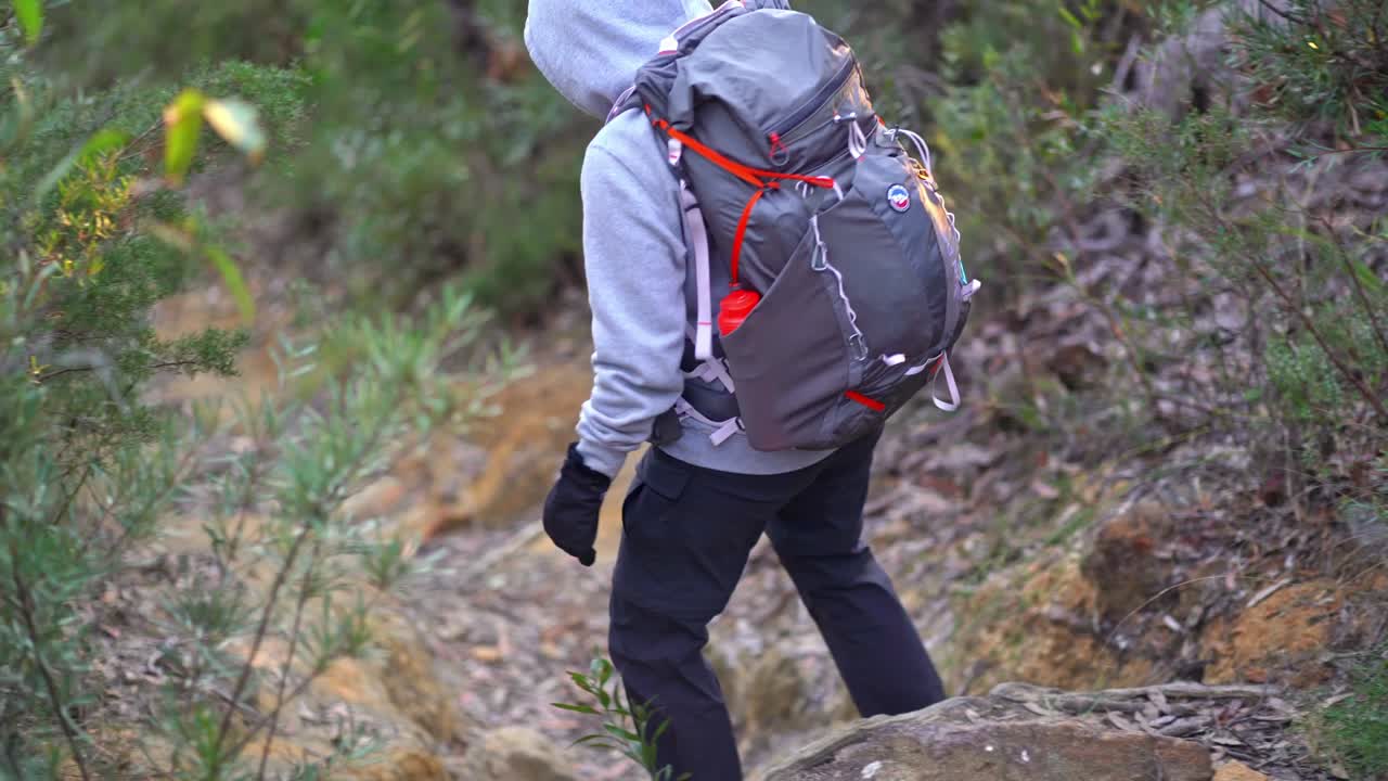 오스트레일리아 숲 을 가로지르는 하이킹 트레일 의 가파른 부분 을 내려가는 오스트레일리아 원주민 여자