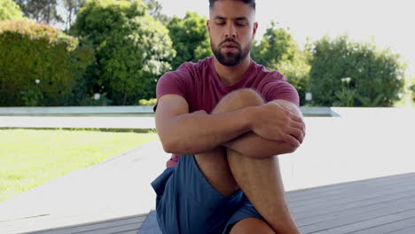 relaxing outdoors, man meditating on deck, enjoying peaceful nature surroundings