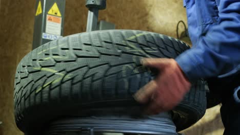 change a tyre, car mechanic is changing a tyre in a garage