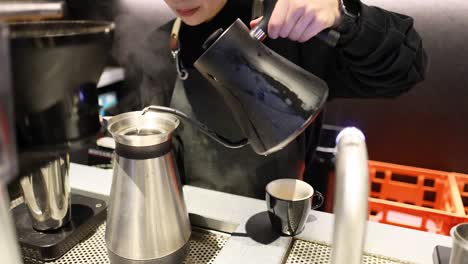 barista pouring coffee into a cup